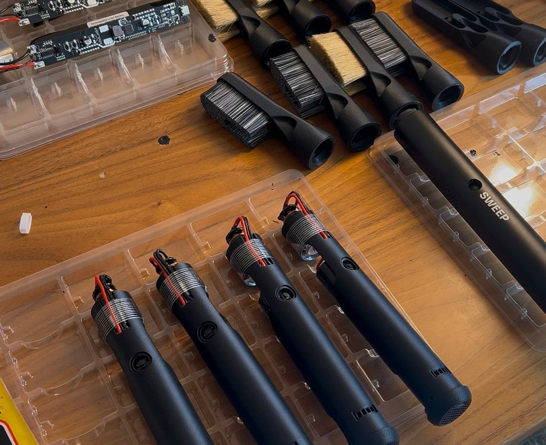 Half assembled chalkblaster on a wooden table with brushes laying around.