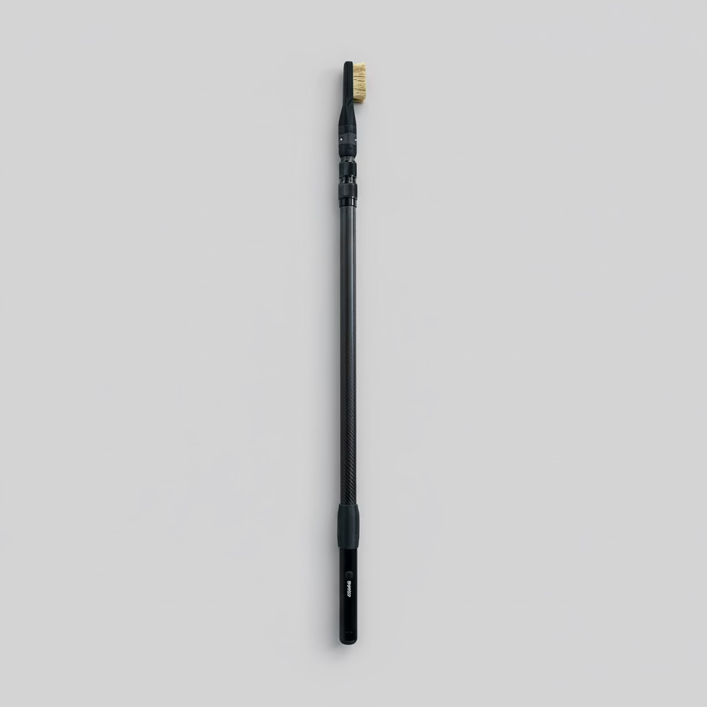 Carbon fibre extension pole with a brush head on one end and the ChalkBlaster connected at the other