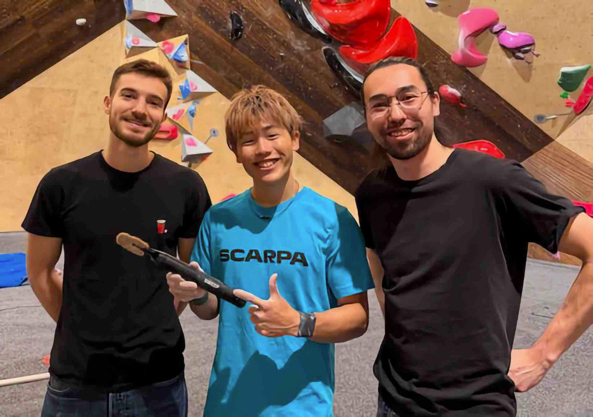 Paul and Kent from SWEEP Climbing with a pro climber holding a ChalkBlaster in front of a bouldering wall